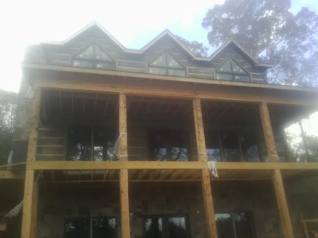Dormers and porch framing on a large log home under construction — Roof Coating work by our crew in Ottsville