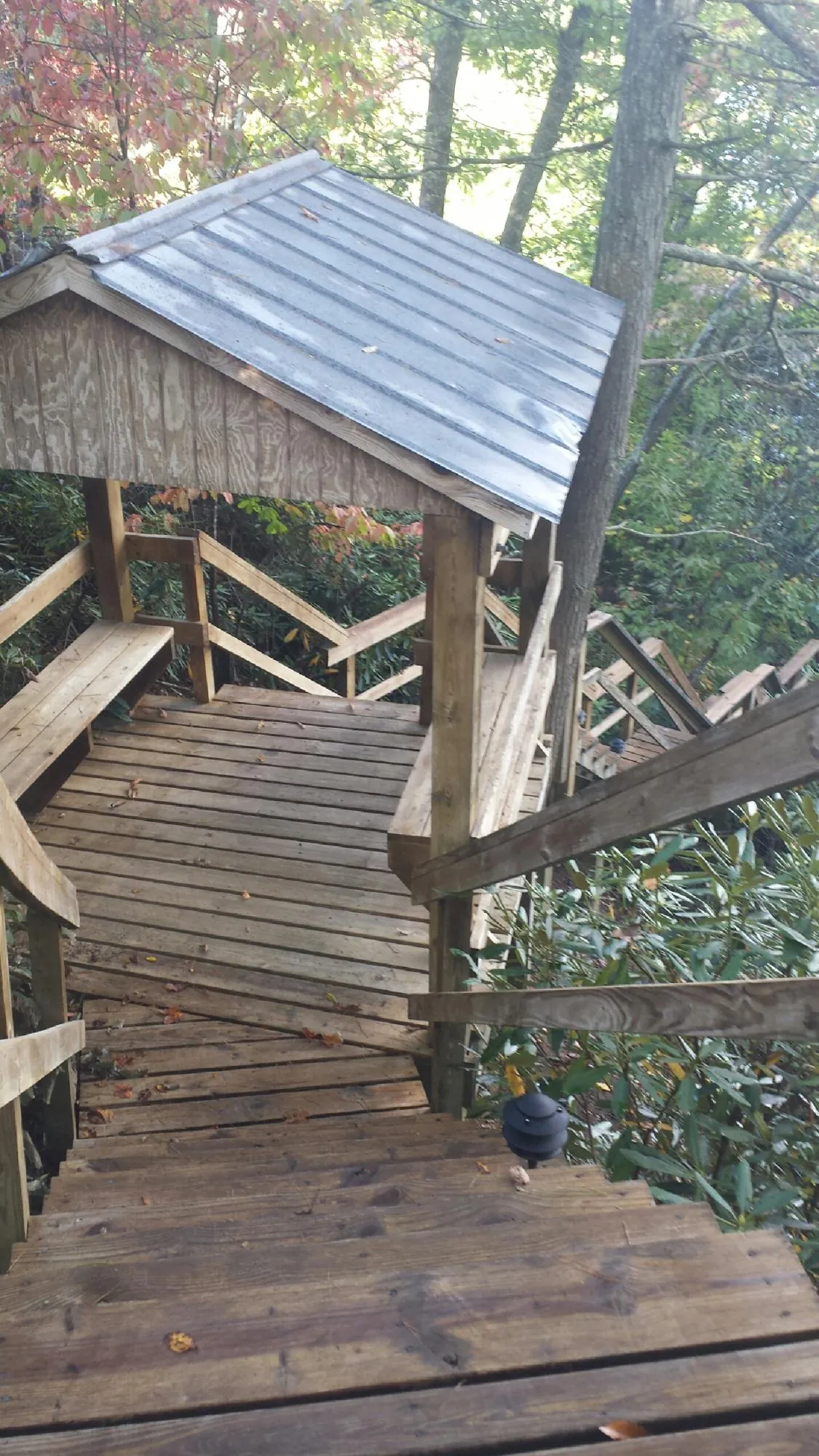 Metal roofed shelter over wooden steps on a wooded walkway — Skylight Repair & Installation work by our crew in Ottsville